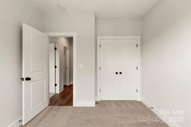 a view of a hallway with closet and wooden floor