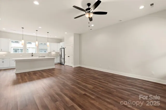 a large kitchen with stainless steel appliances a large window a oven and white cabinets