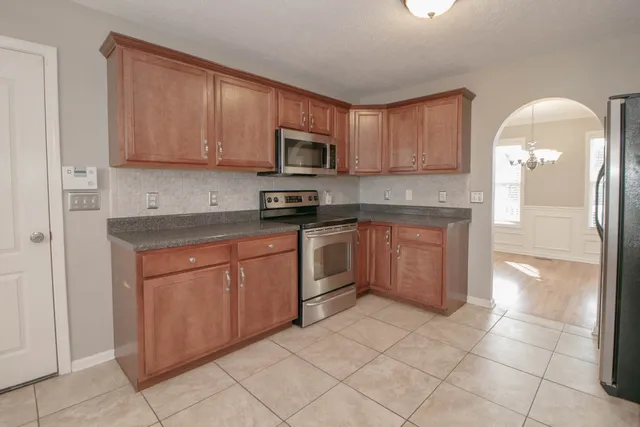 a kitchen with stainless steel appliances granite countertop a stove a sink dishwasher and a refrigerator