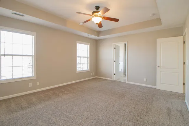 a spacious bathroom with a granite countertop sink a mirror and a bathtub