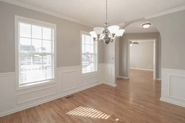 a view of a room with wooden floors and chandelier