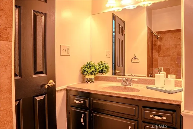a bathroom with a granite countertop sink and a mirror