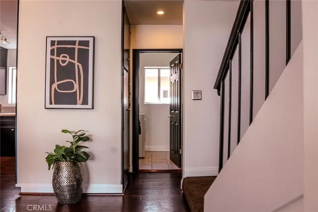 a view of a hallway with wooden floor and stairs
