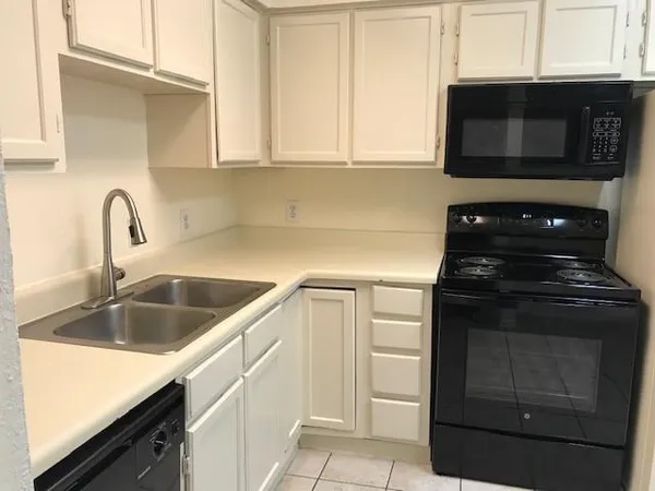 a kitchen with granite countertop white cabinets and stainless steel appliances