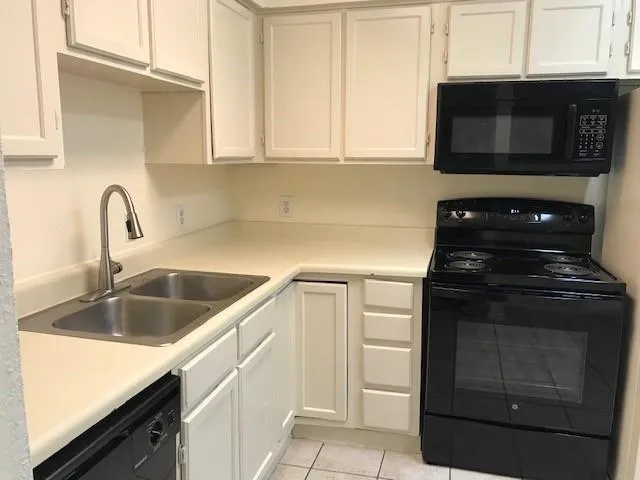 a kitchen with granite countertop white cabinets and stainless steel appliances