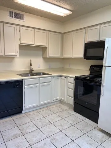 a kitchen with a stove sink and cabinets