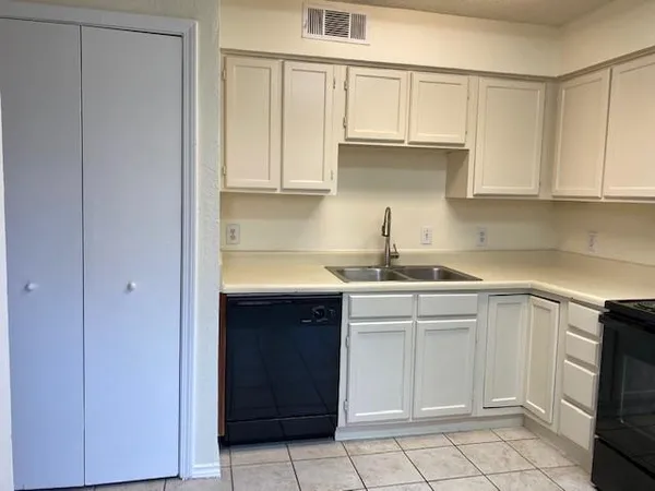 a kitchen with white cabinets and white appliances