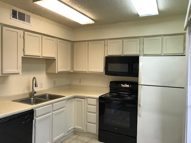 4748 Old Bent Tree Lane, Unit 803 Dallas, TX 75287 - Photo 10 of 18 a kitchen with a sink and a refrigerator