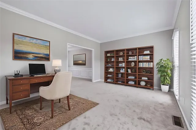 a view of a workspace with furniture and a window