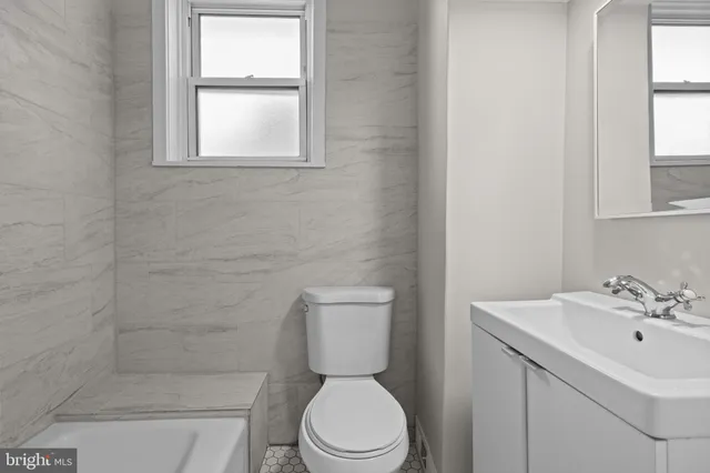 a bathroom with a sink a toilet and a window