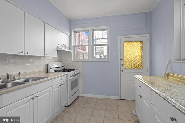 a kitchen with a sink stove and cabinets