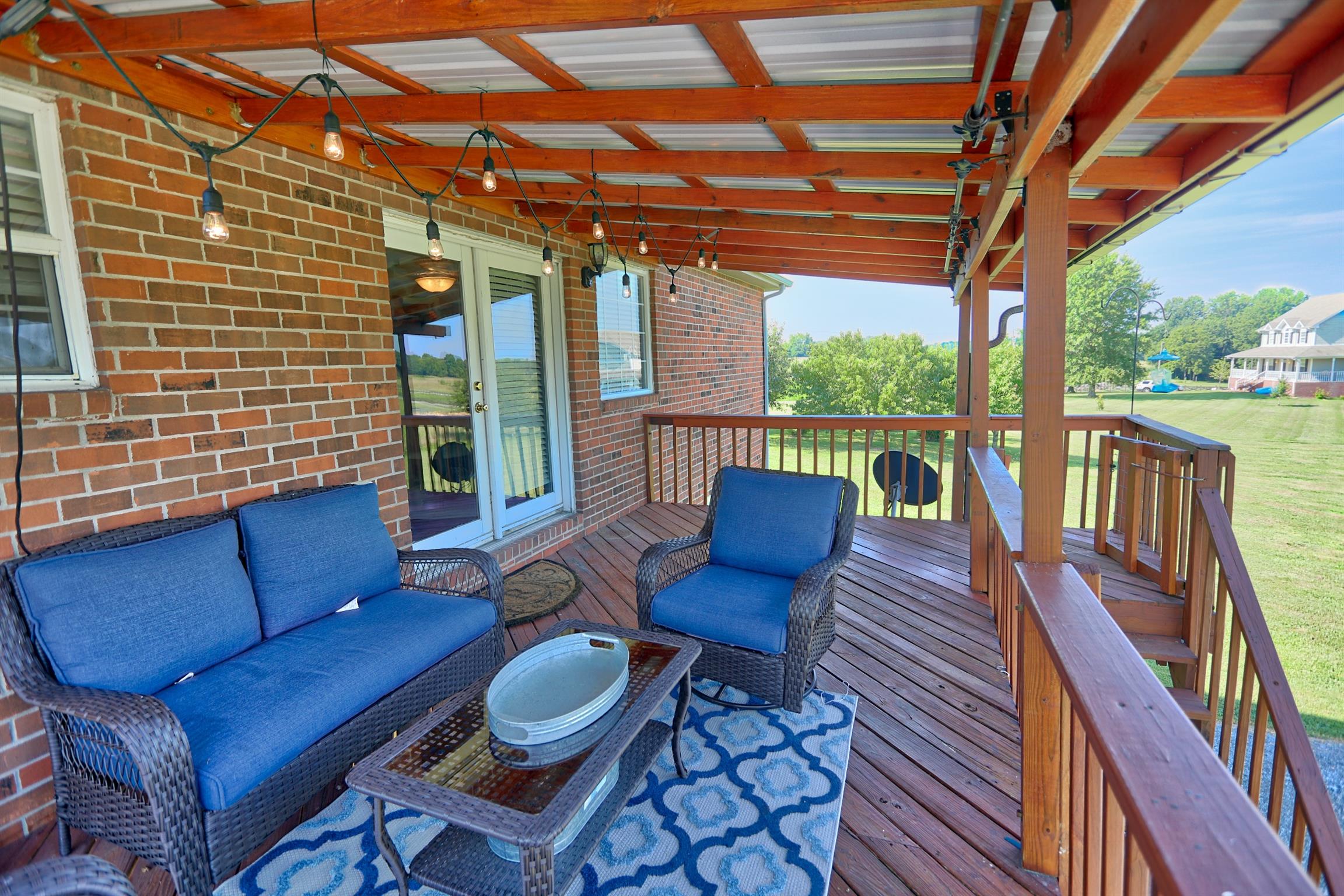 3368 Maxie Jones Road Springfield, TN 37172 - Photo 24 of 27 a view of a patio with couches chairs potted plants and wooden floor