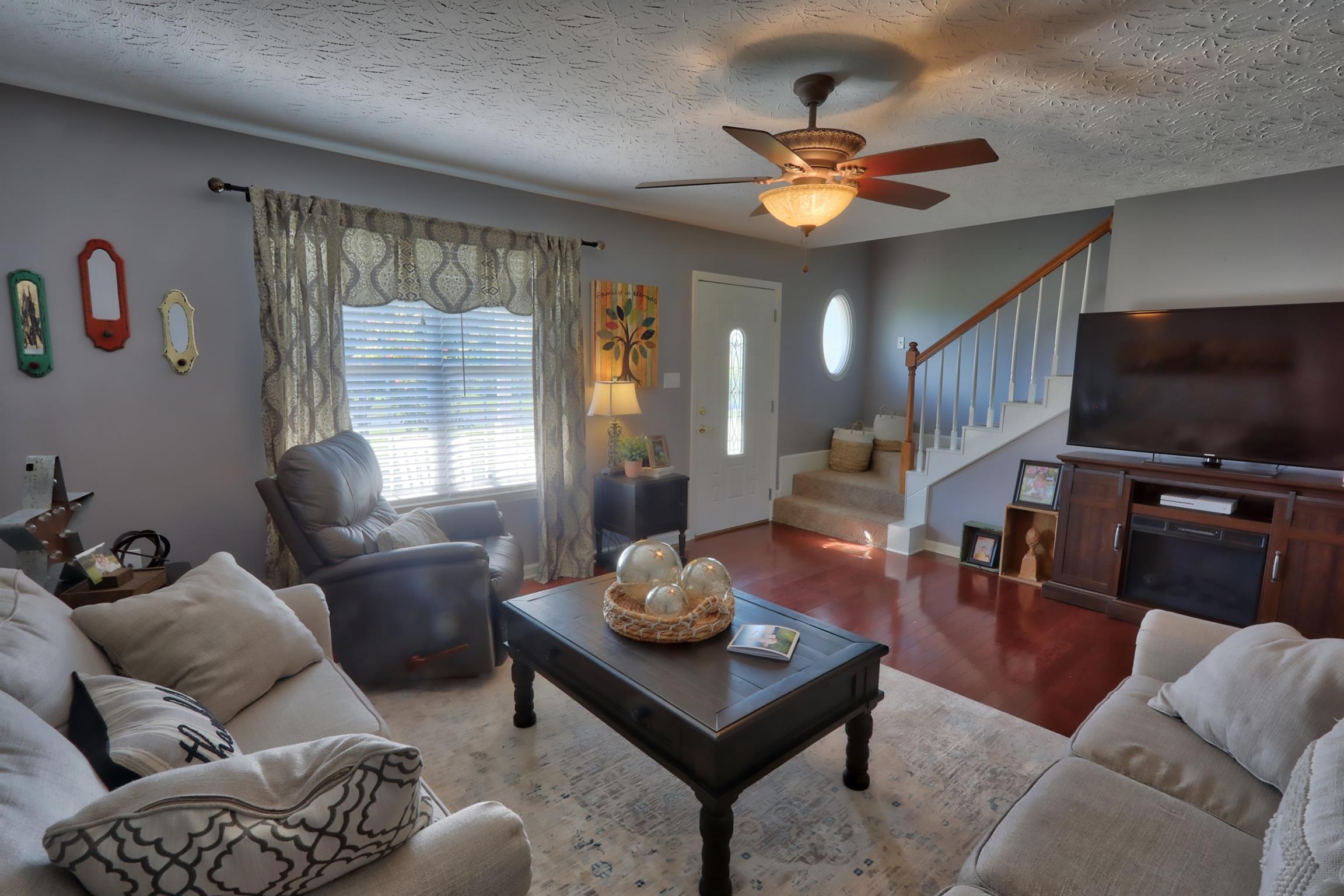 3368 Maxie Jones Road Springfield, TN 37172 - Photo 7 of 27 a living room with furniture a chandelier and a flat screen tv