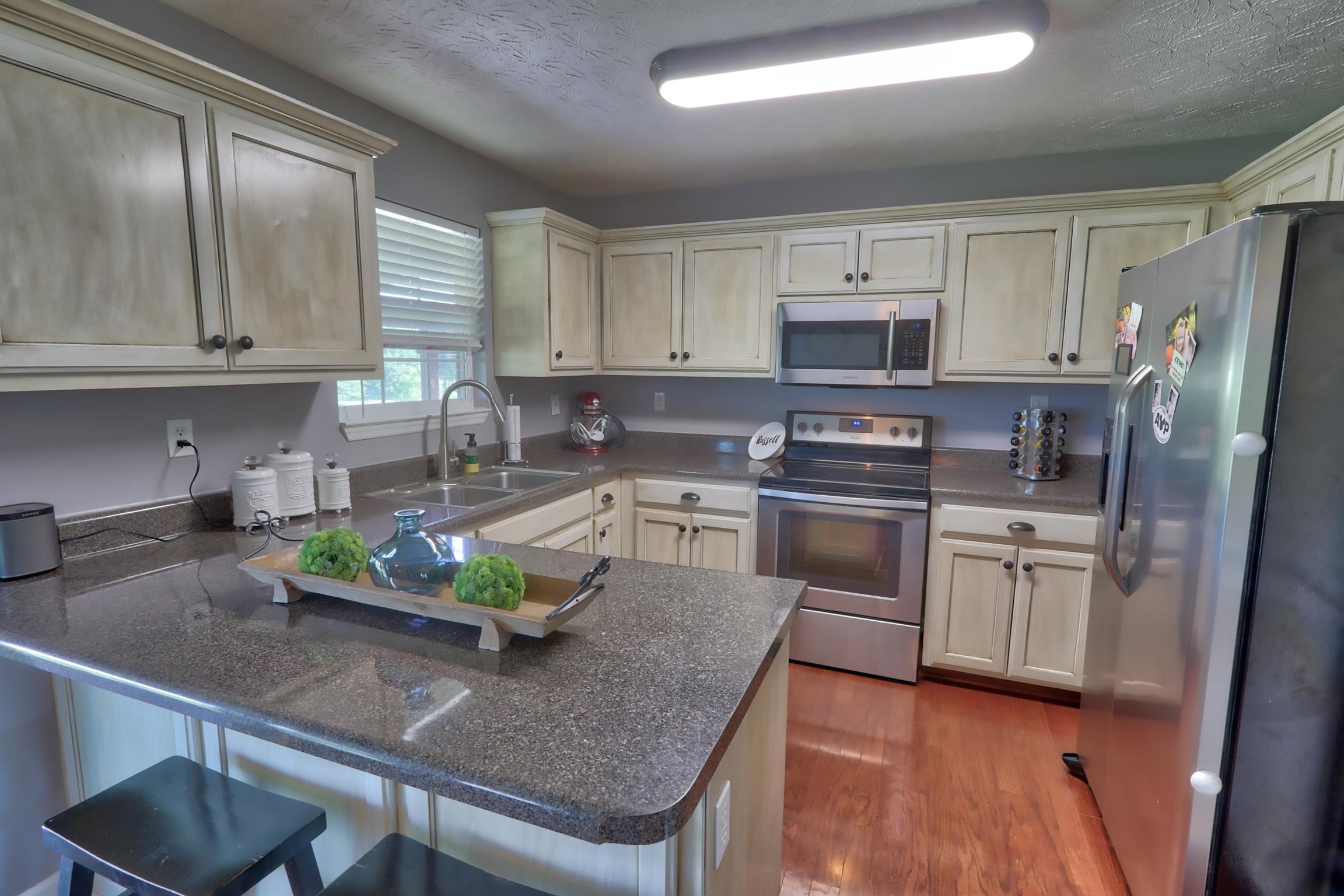 3368 Maxie Jones Road Springfield, TN 37172 - Photo 10 of 27 a kitchen with white cabinets and stainless steel appliances