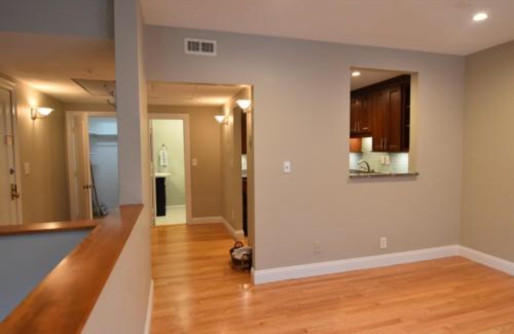 84 Gordon Street, Unit 206 Boston, MA 02135 - Photo 4 of 15 a view of a hallway with wooden floor and a bathroom