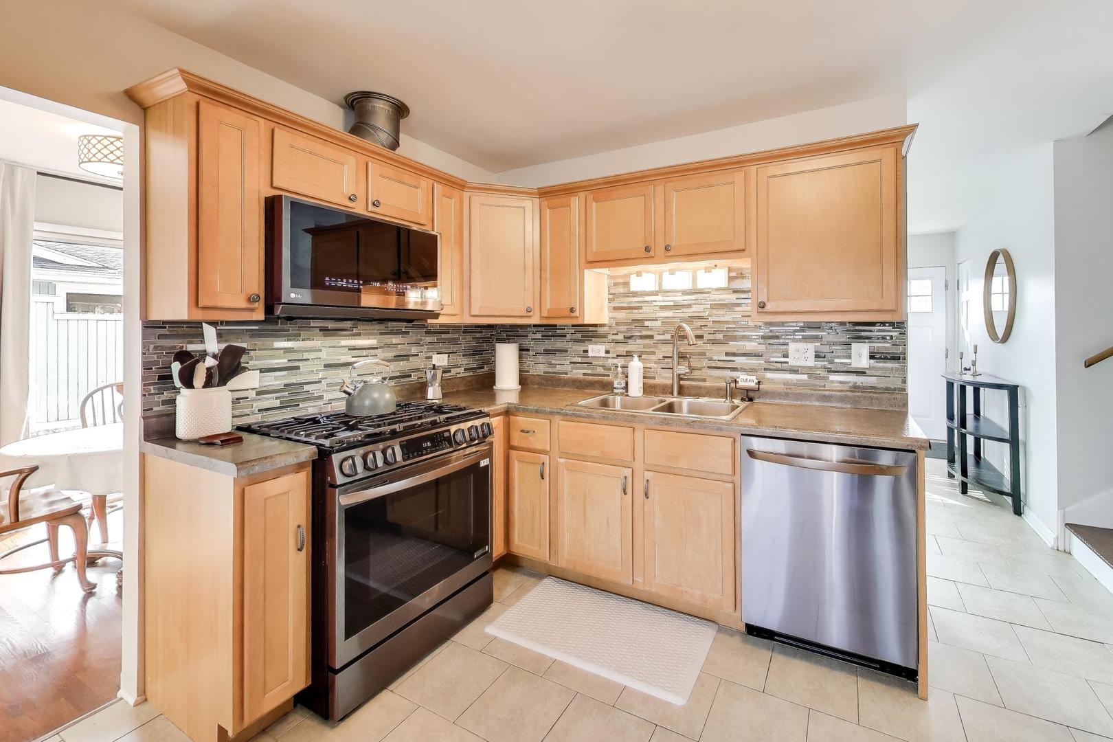 906 Hickory Lane Naperville, IL 60540 - Photo 8 of 30 a kitchen with stainless steel appliances granite countertop a stove microwave and refrigerator