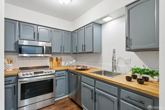 a kitchen with stainless steel appliances a stove microwave and cabinets