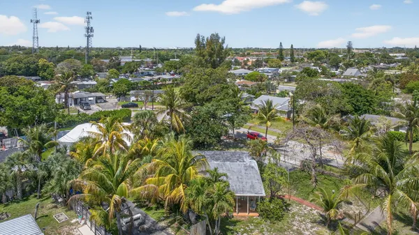 an aerial view of residential houses with outdoor space and trees