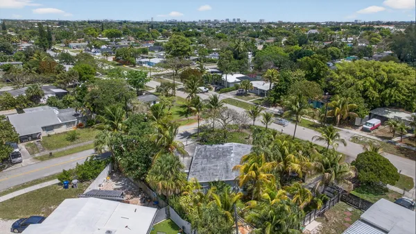 an aerial view of residential houses with outdoor space and trees