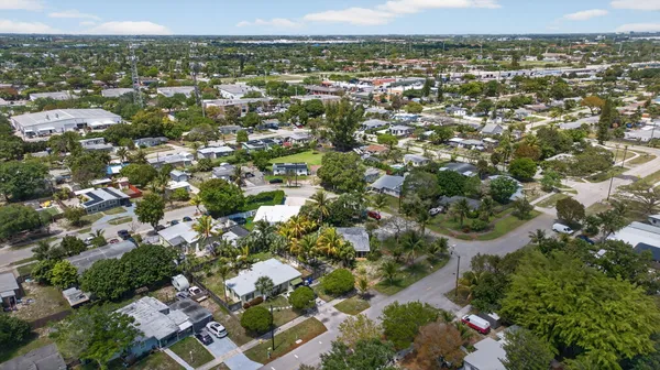 an aerial view of residential houses with outdoor space and trees