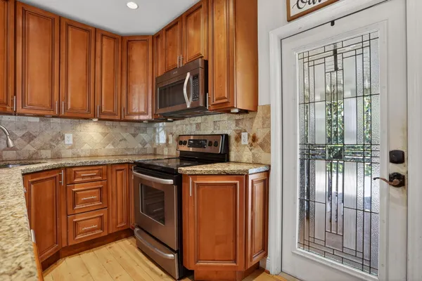 a kitchen with stainless steel appliances granite countertop a sink refrigerator and cabinets