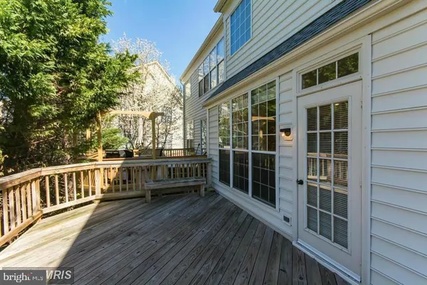 a view of a balcony with couches wooden floor and fence