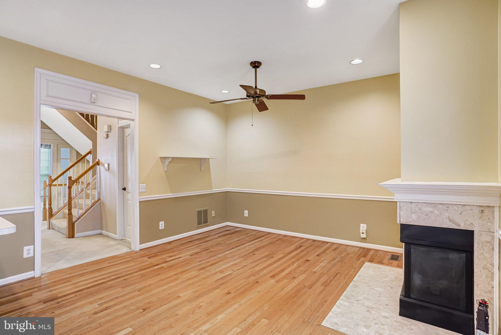 20927 Trinity Square Sterling, VA 20165 - Photo 14 of 47 a view of a room with wooden floor and a ceiling fan