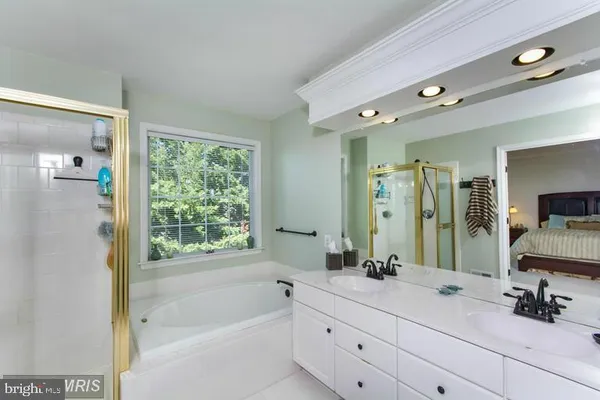 a bathroom with a granite countertop tub sink and mirror