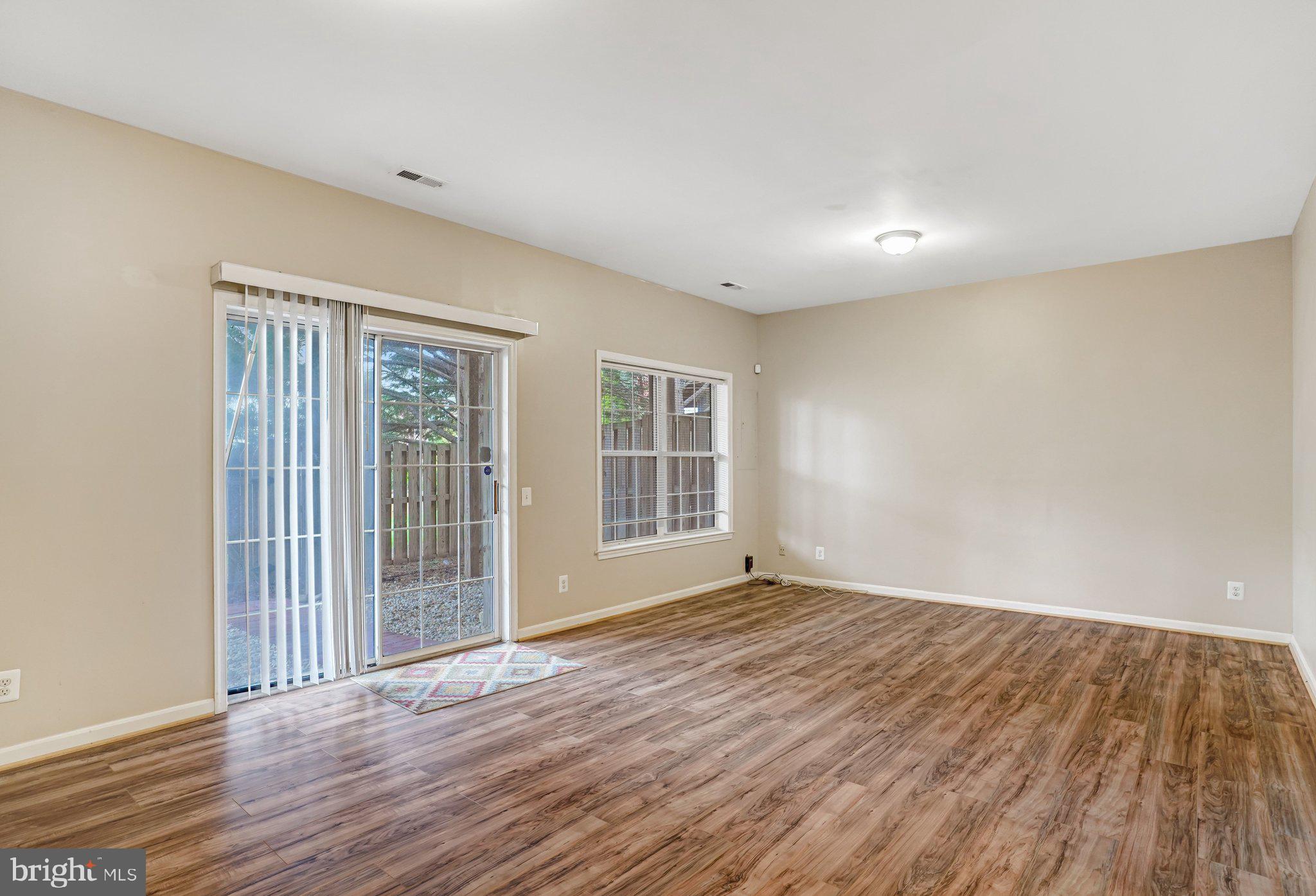 20927 Trinity Square Sterling, VA 20165 - Photo 5 of 47 a view of an empty room with wooden floor and a window