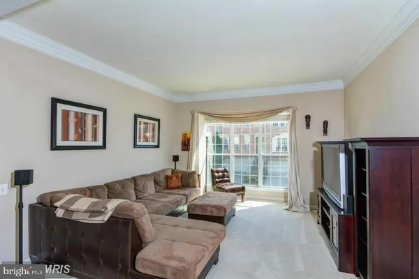a living room with furniture a large window and a flat screen tv