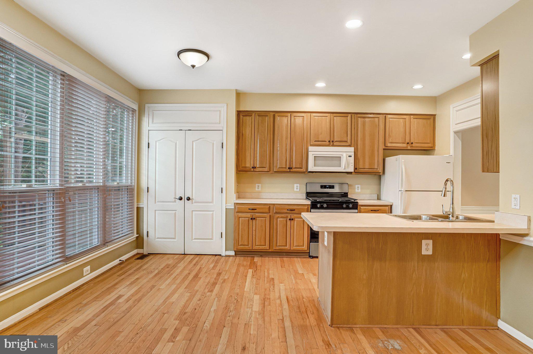 20927 Trinity Square Sterling, VA 20165 - Photo 9 of 47 a kitchen with a sink wooden floor and stainless steel appliances