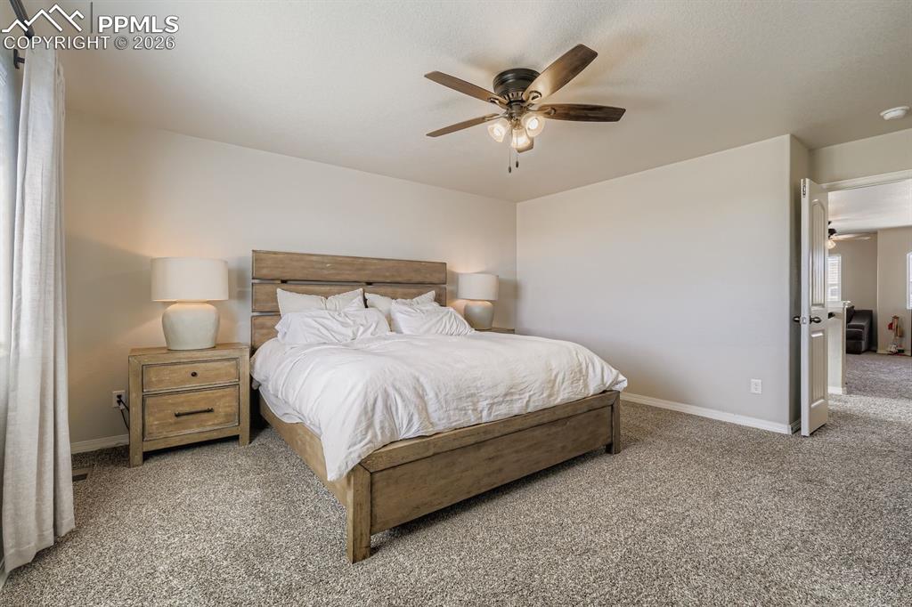 11329 Avena Road Peyton, CO 80831 - Photo 12 of 42 a bedroom with a bed and a chandelier