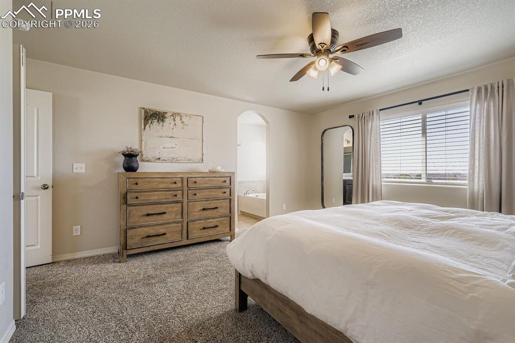 11329 Avena Road Peyton, CO 80831 - Photo 13 of 42 a bedroom with a bed and a chandelier