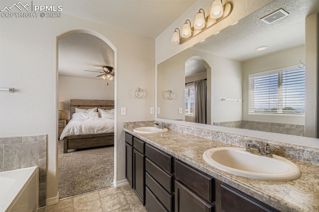 11329 Avena Road Peyton, CO 80831 - Photo 15 of 42 a en suite bathroom with a granite countertop double vanity sink and a mirror