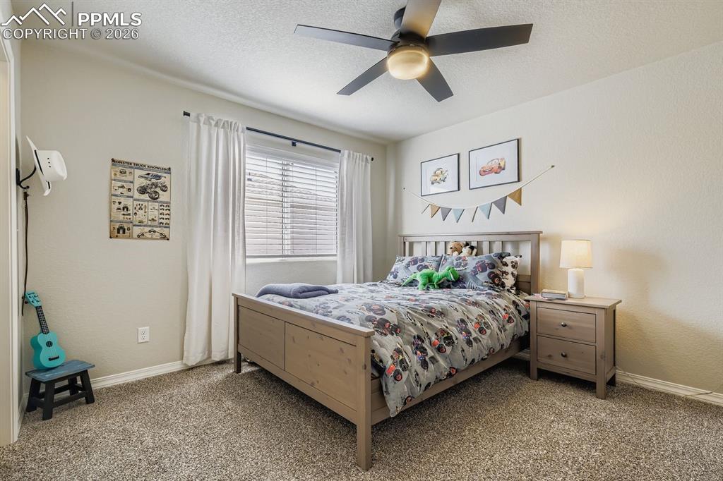 11329 Avena Road Peyton, CO 80831 - Photo 16 of 42 a bedroom with a bed and a chandelier