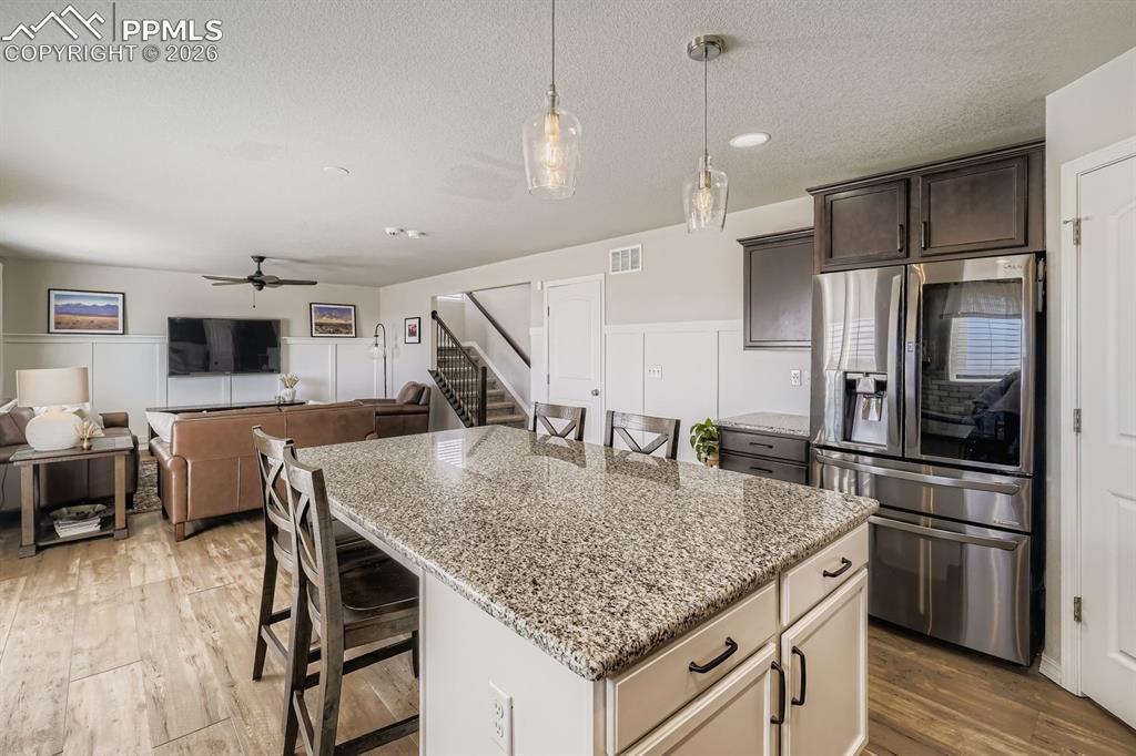 11329 Avena Road Peyton, CO 80831 - Photo 3 of 42 a kitchen with stainless steel appliances granite countertop a kitchen island a stove and a refrigerator
