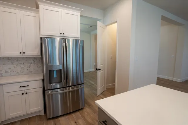 a kitchen with stainless steel appliances a refrigerator and wooden floor