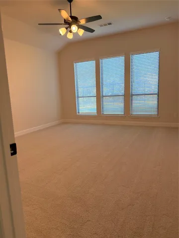 an empty room with windows and fan