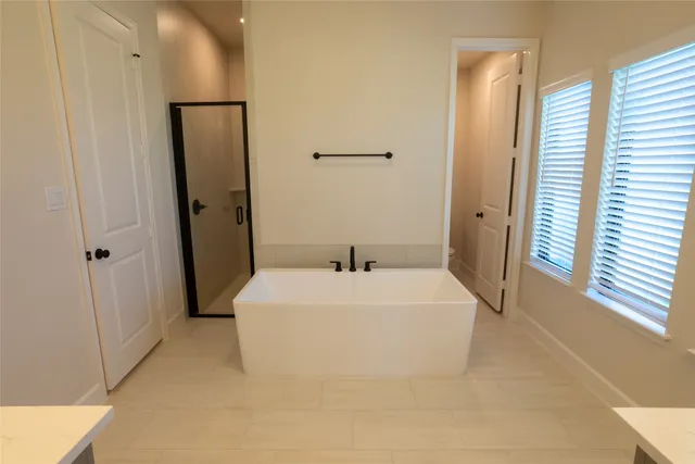 a white bed sitting in a bathroom