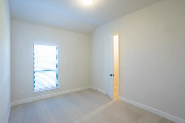 an empty room with a ceiling fan and windows