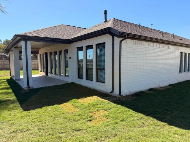 a view of a house with backyard and porch
