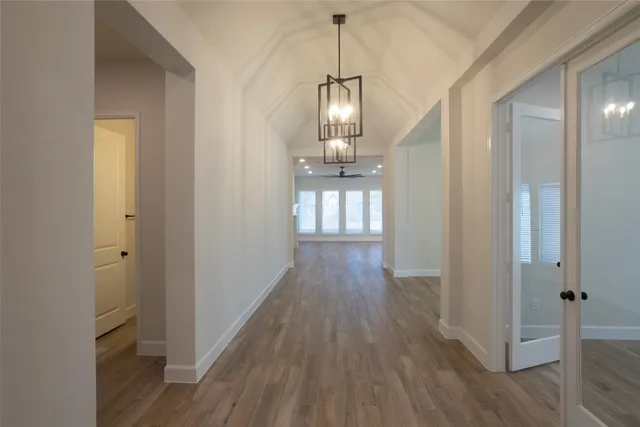 a view of a hallway with wooden floor and staircase