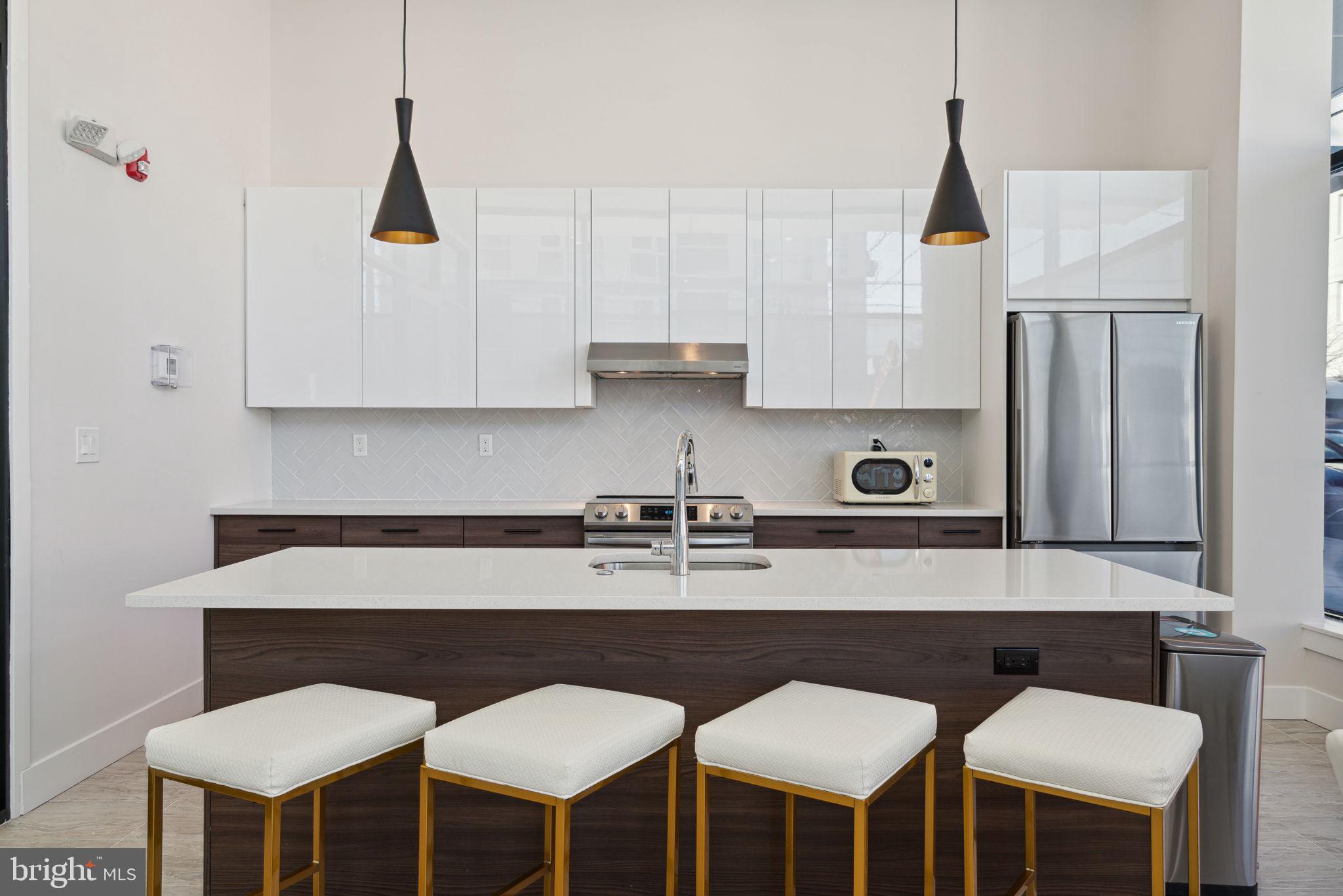 720 West Thompson Street, Unit 1B208 Philadelphia, PA 19122 - Photo 27 of 32 a kitchen with a dining table chairs and a refrigerator