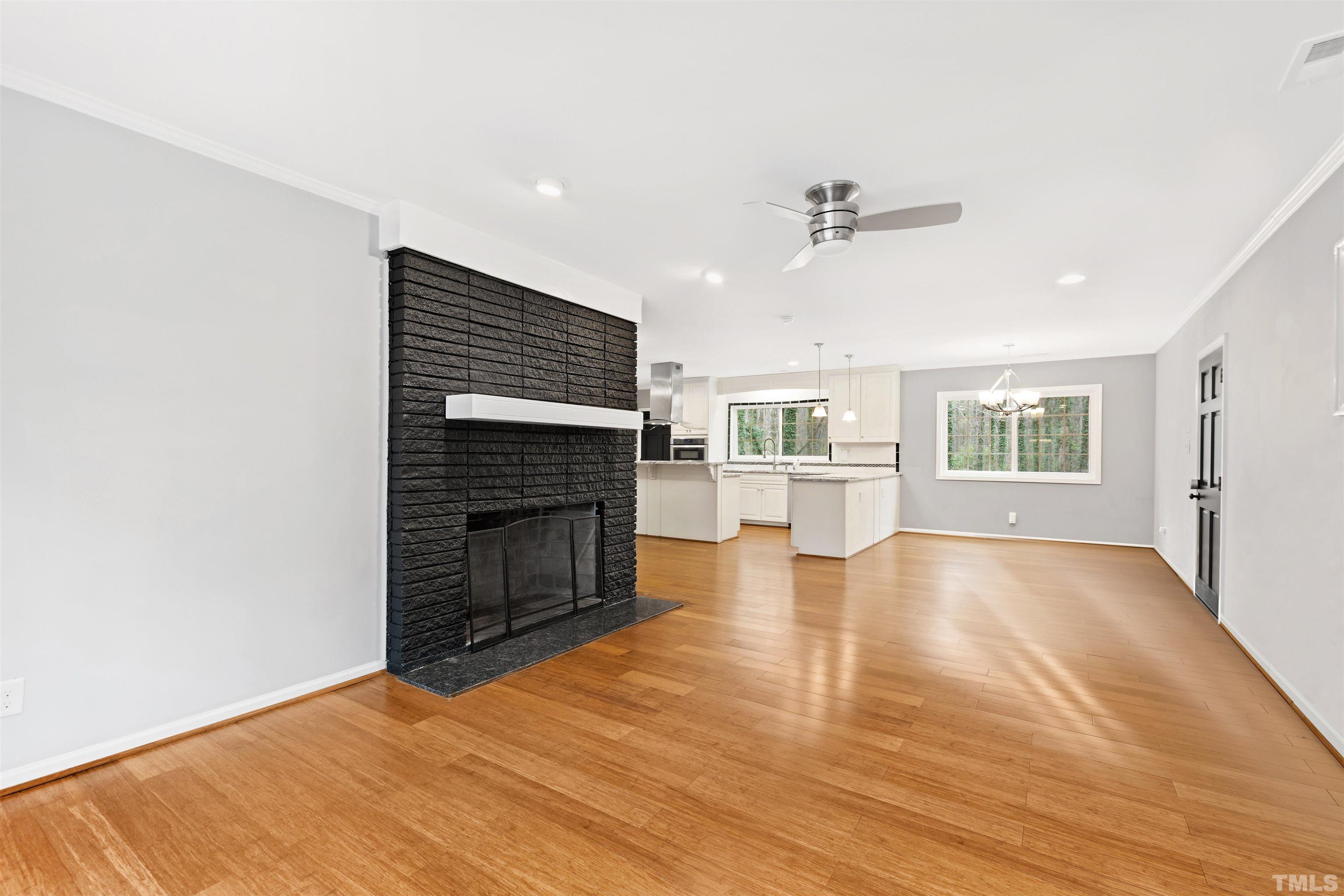 2528 Optimist Farm Road Apex, NC 27539 - Photo 11 of 49 an empty room with wooden floor fireplace and windows