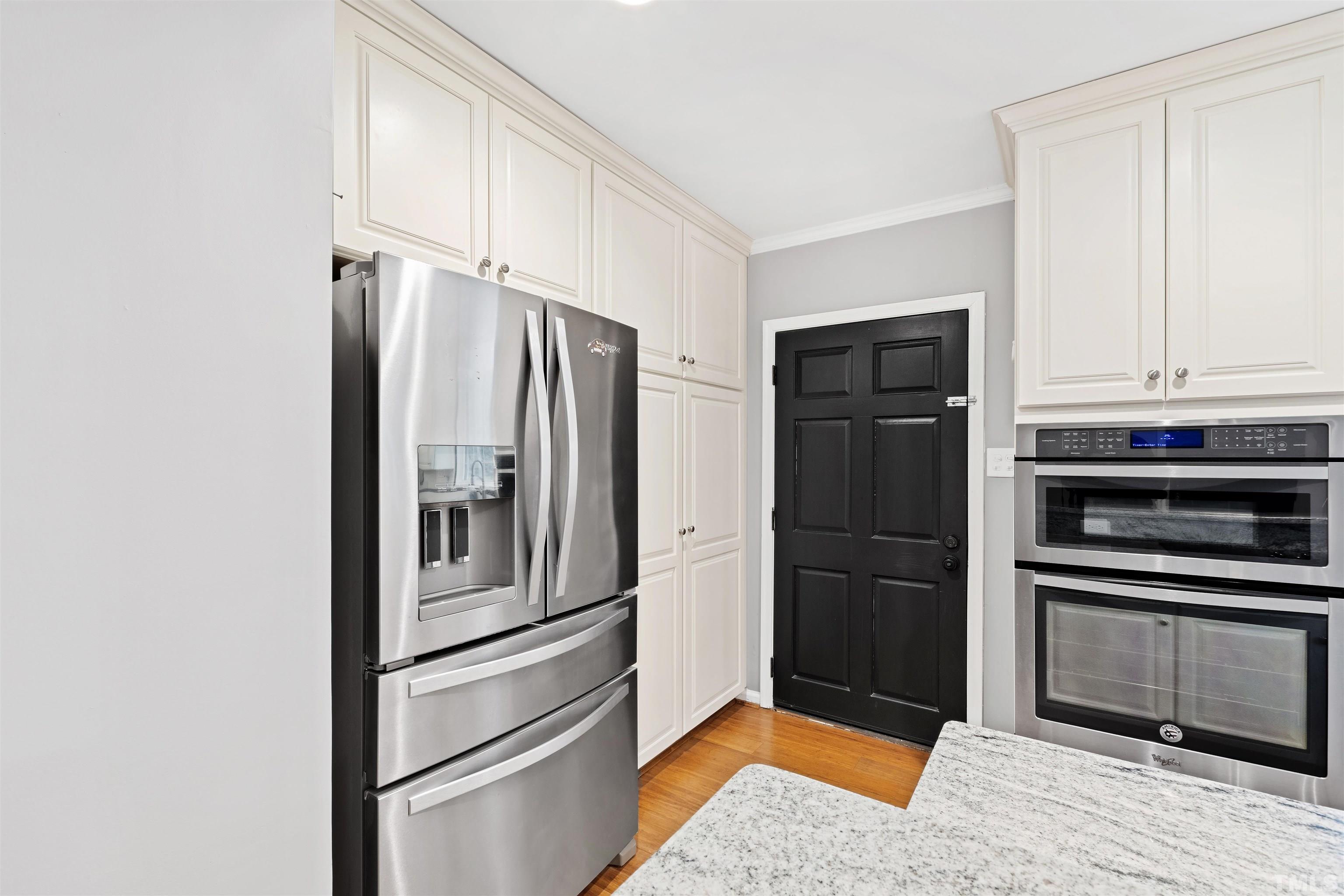2528 Optimist Farm Road Apex, NC 27539 - Photo 14 of 49 a kitchen with a refrigerator stainless steel appliances wooden floor and cabinets