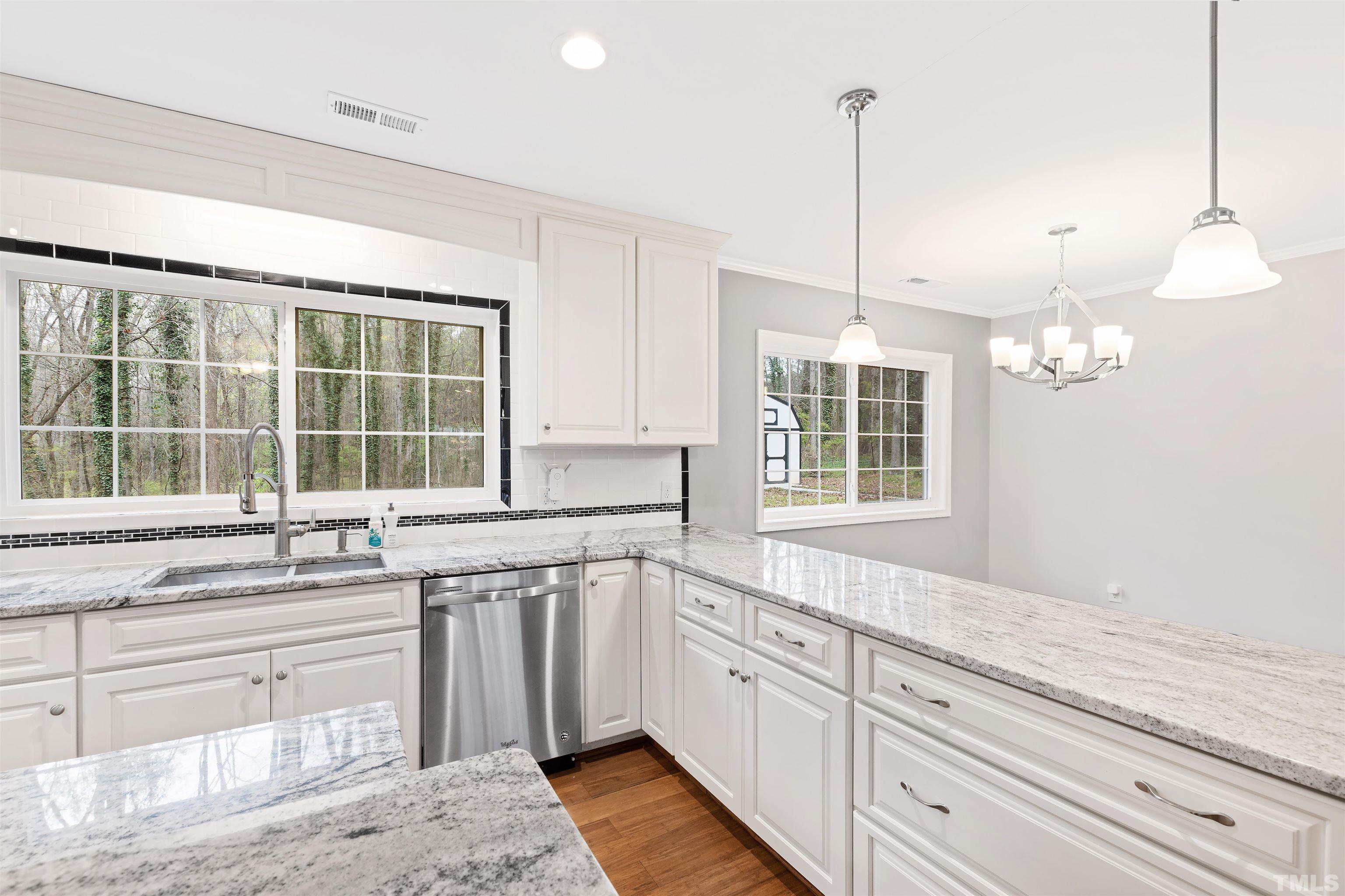 2528 Optimist Farm Road Apex, NC 27539 - Photo 20 of 49 a kitchen with granite countertop cabinets a sink a window and stainless steel appliances