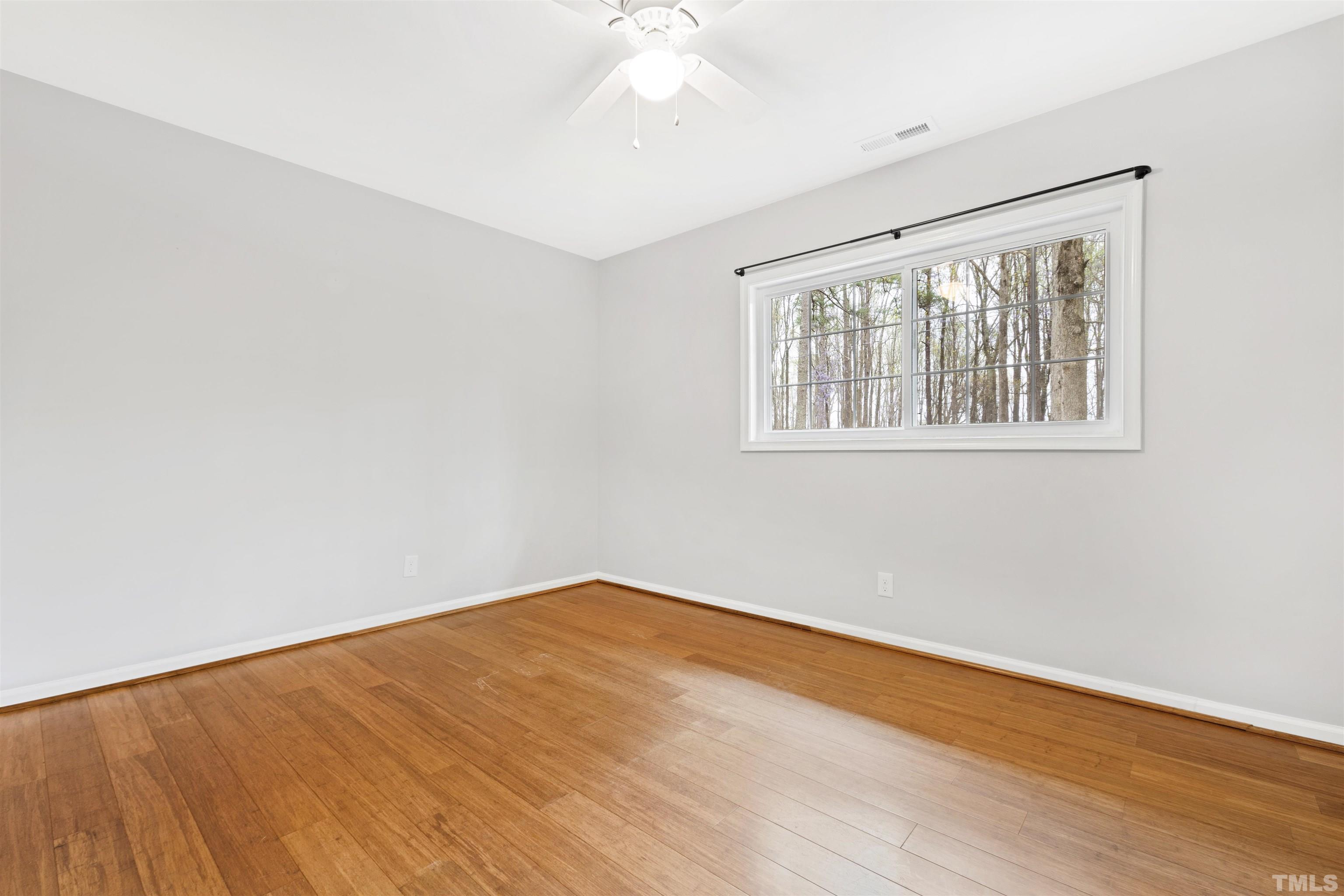 2528 Optimist Farm Road Apex, NC 27539 - Photo 33 of 49 a view of an empty room with wooden floor and a window