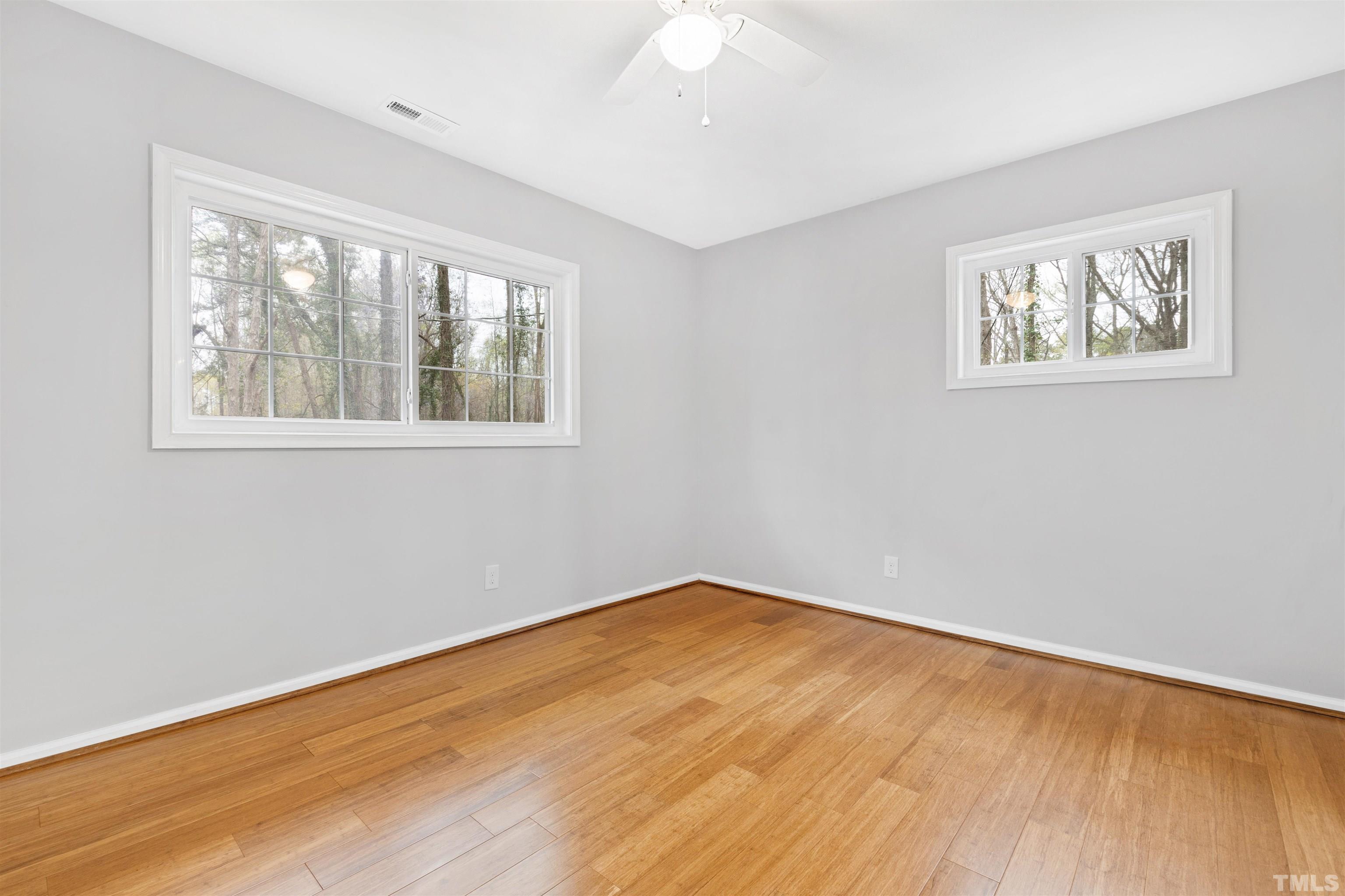 2528 Optimist Farm Road Apex, NC 27539 - Photo 35 of 49 a view of empty room with wooden floor and fan