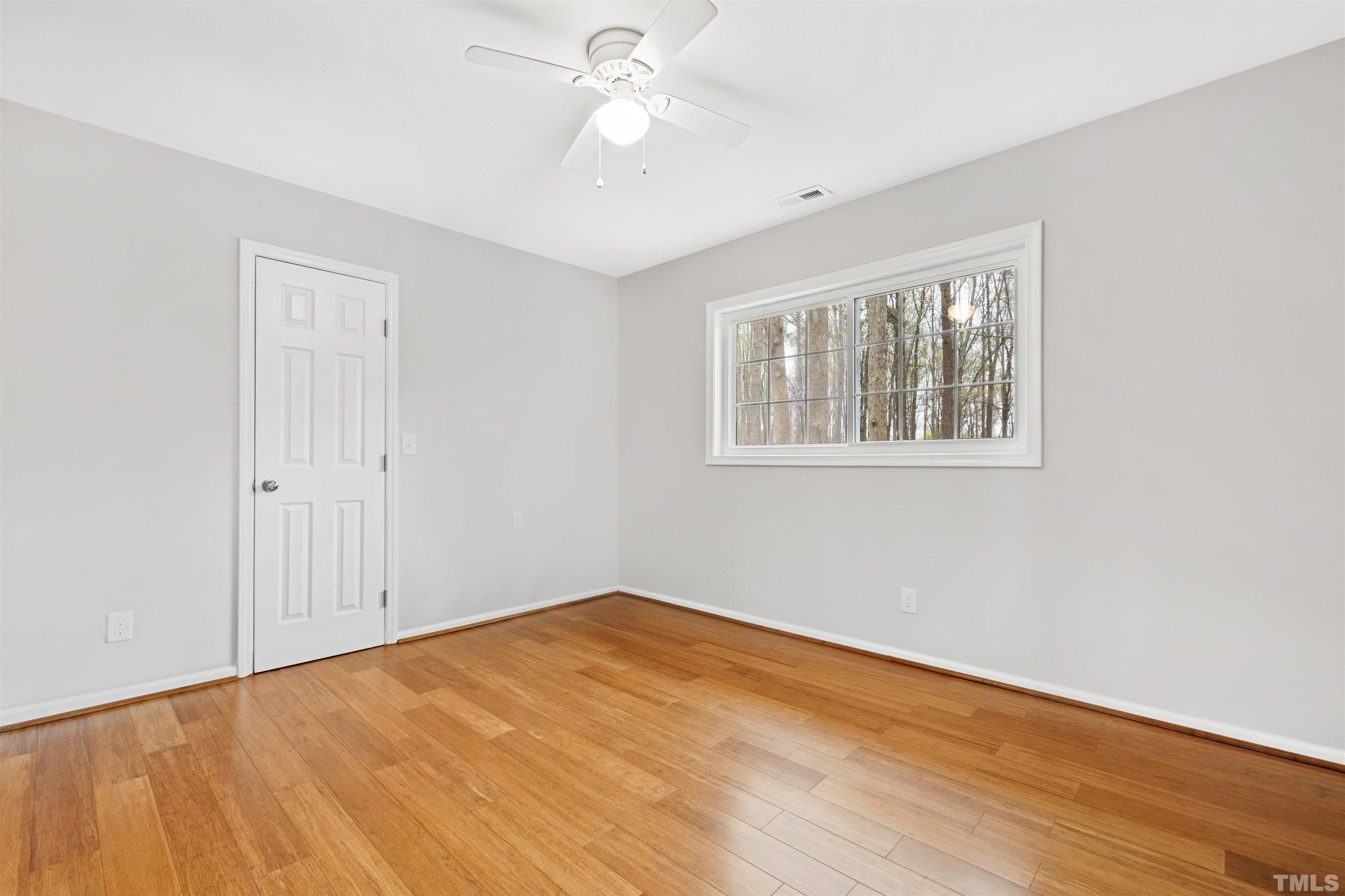 2528 Optimist Farm Road Apex, NC 27539 - Photo 37 of 49 a view of an empty room with wooden floor and a window