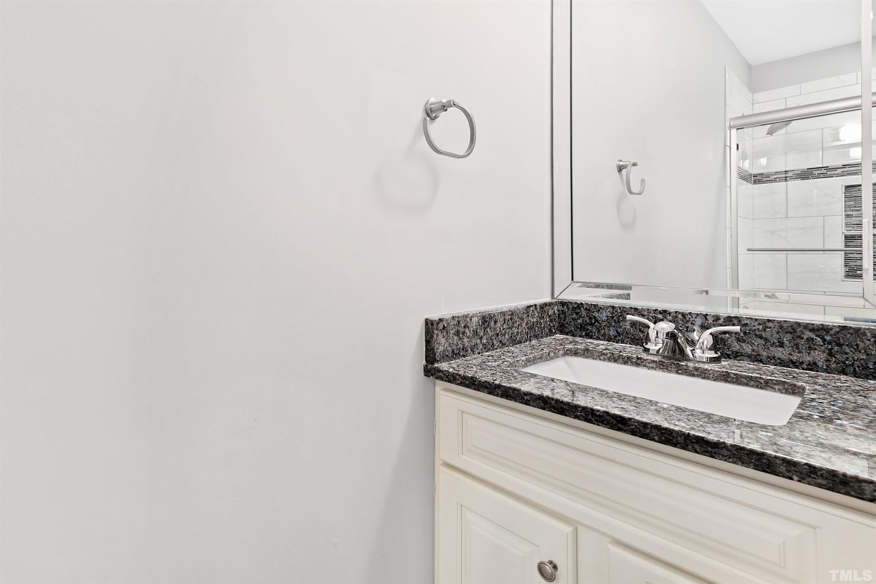2528 Optimist Farm Road Apex, NC 27539 - Photo 40 of 49 a bathroom with a granite countertop sink and a mirror